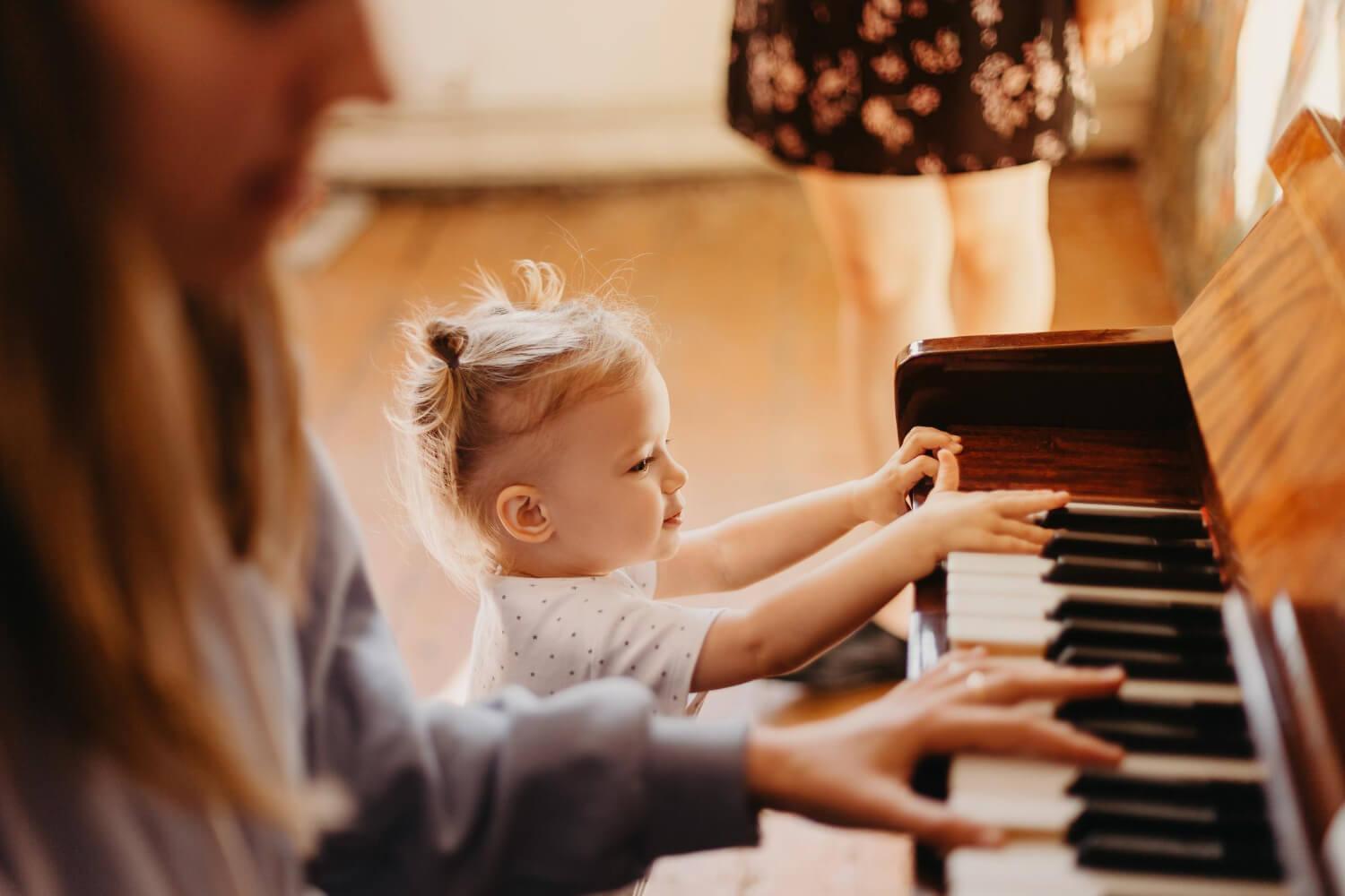 Małe dziecko poznające instrument muzyczny Małe dziecko poznające instrument muzyczny